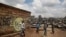 FILE - Children walk past graffiti depicting a representation of the coronavirus and warning people to sanitize to prevent its spread, in the Mathare slum of Nairobi, Kenya, April 22, 2020.