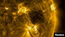 This file photo shows a medium-sized (M2) solar flare and a coronal mass ejection (CME) erupting from the same, large active region of the Sun on July 14, 2017. (NASA/GSFC/Solar Dynamics Observatory/Handout via REUTERS)