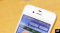 A woman uses an Apple iPhone 4 smartphone for Web surfing during a photo opportunity at an Apple store in Seoul, May 24, 2011