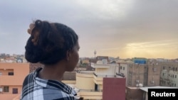 FILE: A woman looks at the city from the rooftop of her house during the conflict in Khartoum, Sudan, April 30, 2023.