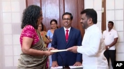 National People's Power lawmaker Harini Amarasuriya, 54, left, takes the oath for the post of prime minister in front of President Anura Kumara Dissanayake, in Colombo, Sri Lanka, Sept. 23, 2024. (Sri Lanka Government Information Department via AP)