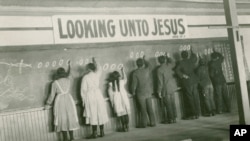 FILE - In this 1910s photo provided by the United Church of Canada Archives, students write on a chalkboard at the Red Deer Indian Industrial School in Alberta.