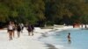 FILE - Tourists walk along a beach on Koh Rong island in Sihanoukville province on October 31, 2019.