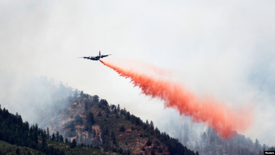 Pesawat militer AS jenis C-130 menjatuhkan air untuk memadamkan kebakaran hutan di Waldo Canyon, sebelah barat kota Colorado Springs.