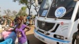 FILE - A woman from South Sudan stands in front of a UNHCR passenger bus at a refugee registration site near Bidi Bidi, Uganda, Dec. 11, 2016. The U.N. refugee agency reports that 1.6 million South Sudanese have now fled to neighboring countries.