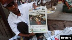 A news vendor displays local newspapers on a street in Yangon November 9, 2015. Voting unfolded smoothly in Myanmar on Sunday with no reports of violence to puncture a mood of jubilation marking the Southeast Asian nation's first free nationwide election 