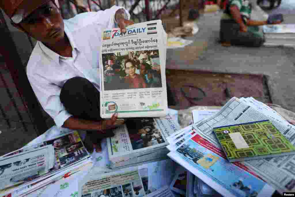 Seorang penjual koran memperlihatkan koran lokal di sebuah jalan di Yangon, Myanmar (9/11).(Reuters/Soe Zeya Tun)