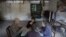 Patients and their relatives play cards in a dilapidated service building at Yangjia Hospital in Wuyi County, Zhejiang Province, China, Oct. 19, 2015. 