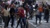 Anti-Morsi protesters throw stones towards riot police during clashes in Simon Bolivar Square, which leads to Tahrir Square, in Cairo, Egypt, January 30, 2013.