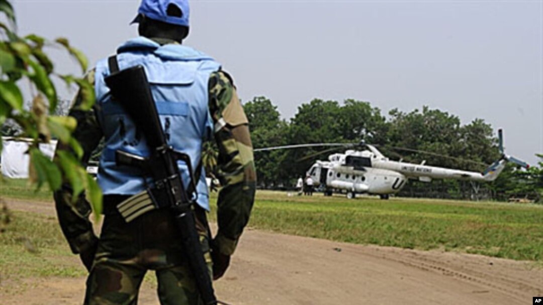 An U.N. peacekeeper in Ivory Coast stands guard by an UN helicopter used to transport officials and journalists from UNOCI headquarters to the Hotel du Golf, the temporary headquarters of Alassane Ouattara, in Abidjan, 3 Jan 2011