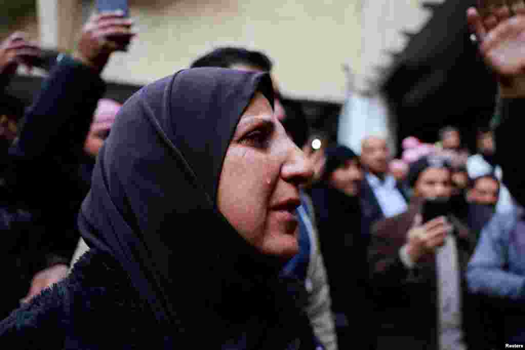 A woman reacts as people join members of the Syrian civil defense group, known as the White Helmets, in search of prisoners at the Sednaya prison in Sednaya, Dec. 11, 2024.