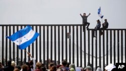 Migran Amerika Tengah duduk di atas dinding perbatasan pantai di San Diego saat berlangsungnya pertemuan para migran yang tinggal di kedua sisi perbatasan, 29 April 2018.