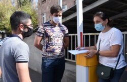 A woman collects data as people queue to donate blood for those who were injured during clashes in the breakaway region of Nagorno-Karabakh, near the Hematology Center in Yerevan, Armenia, Sept. 28, 2020. (Photolure via Reuters)