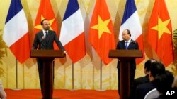 French Primer Minister Edouard Philippe (L) looks on as Vietnam's Prime Minister Nguyen Xuan Phuc speaks during their joint press conference at International Convention Center in Hanoi, Nov. 2, 2018.