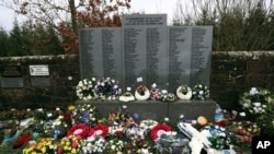 FILE - Floral tributes are laid by the main memorial stone in memory of the victims of Pan Am flight 103 bombing, in the garden of remembrance at Dryfesdale Cemetery, near Lockerbie, Scotland, Dec. 21, 2018.