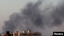 Black smoke marks where clashes are taking place between pro-government forces and an alliance of anti-Moammar Gadhafi rebels who have joined forces with the Islamist group Ansar al-Sharia in Benghazi, Libya, Aug. 15, 2015. 