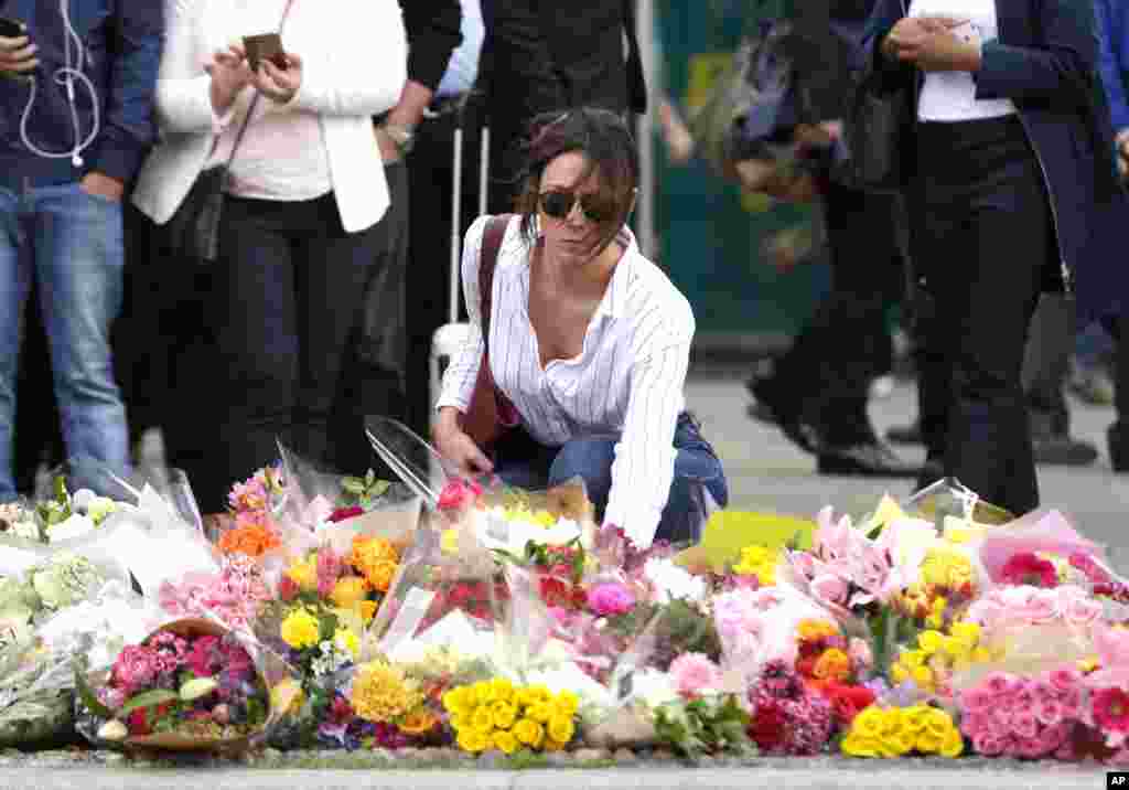 Seorang perempuan meletakkan karangan bunga di kawasan London Bridge, London, 5 Juni 2017.