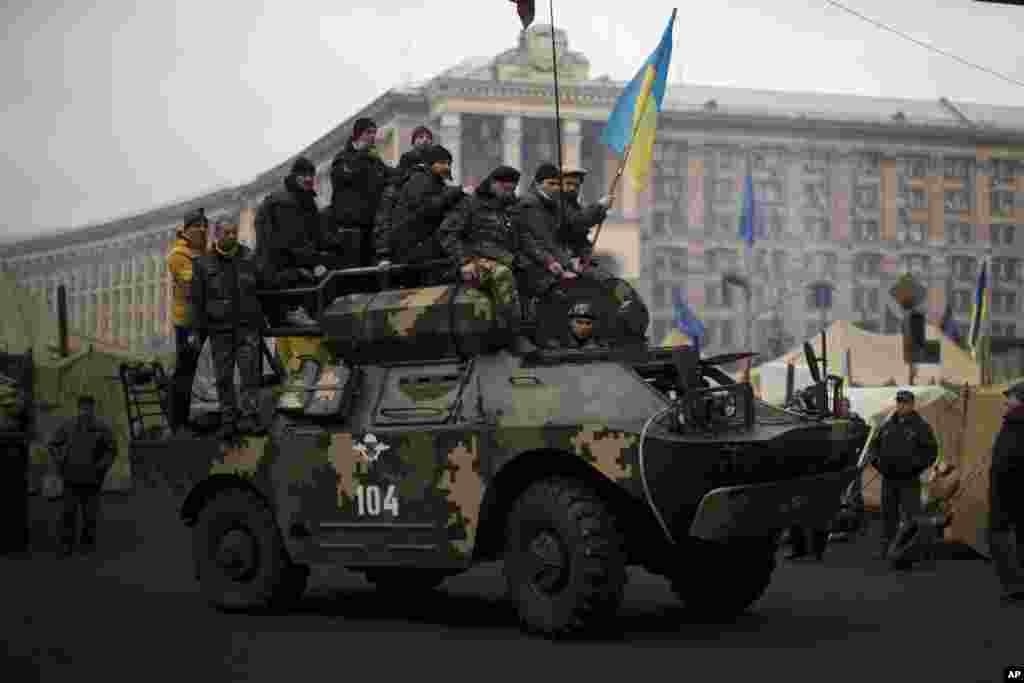 Anti-Yanukovych protesters riding on top of a military armored vehicle in Independence Square, the epicenter of the country&#39;s current unrest, in Kyiv, Feb. 27, 2014.&nbsp;