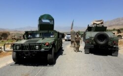 FILE - Afghan National Army soldiers patrol the area near a checkpoint recaptured from the Taliban, in the Alishing district of Laghman province, Afghanistan, July 8, 2021.