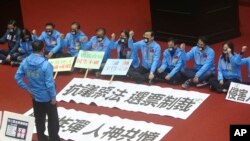 Legislators of the Nationalist Party protest the Anti-infiltration Bill with slogans reading ''Protest against a bad law, Sanction by Votes. Neck Bomb, Be hated by both man and God' on the legislature floor in Taipei, Taiwan, Dec. 31, 2019. 