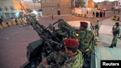 Houthi fighters in army uniforms patrol outside the presidential palace in Sana'a, Yemen, Feb. 6, 2015.