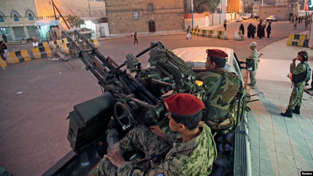 FILE - Houthi fighters in army uniforms patrol outside the presidential palace in Sana'a, Yemen, Feb. 6, 2015.