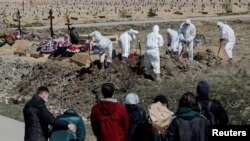 Des personnes en deuil se rassemblent pour l'enterrement d'une victime de la maladie à coronavirus (COVID-19) dans le cimetière de la périphérie de Saint-Pétersbourg, en Russie, le 5 mai 2020. REUTERS / Anton Vaganov IMAGES TPX DU JOUR