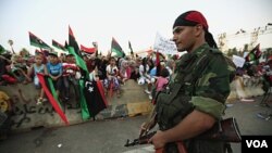 Seorang pasukan anti Gaddafi menjaga keamanan para demontsran di Martyrs Square, Tripoli, Libya (2/9).