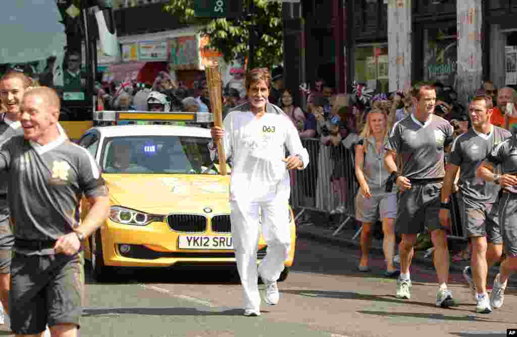 Aktor Bollywood Amitabh Bachchan membawa obor Olimpiade antara pusat kota London dan distrik Southwark, juga di London (25/7). (Foto: LOCOG)