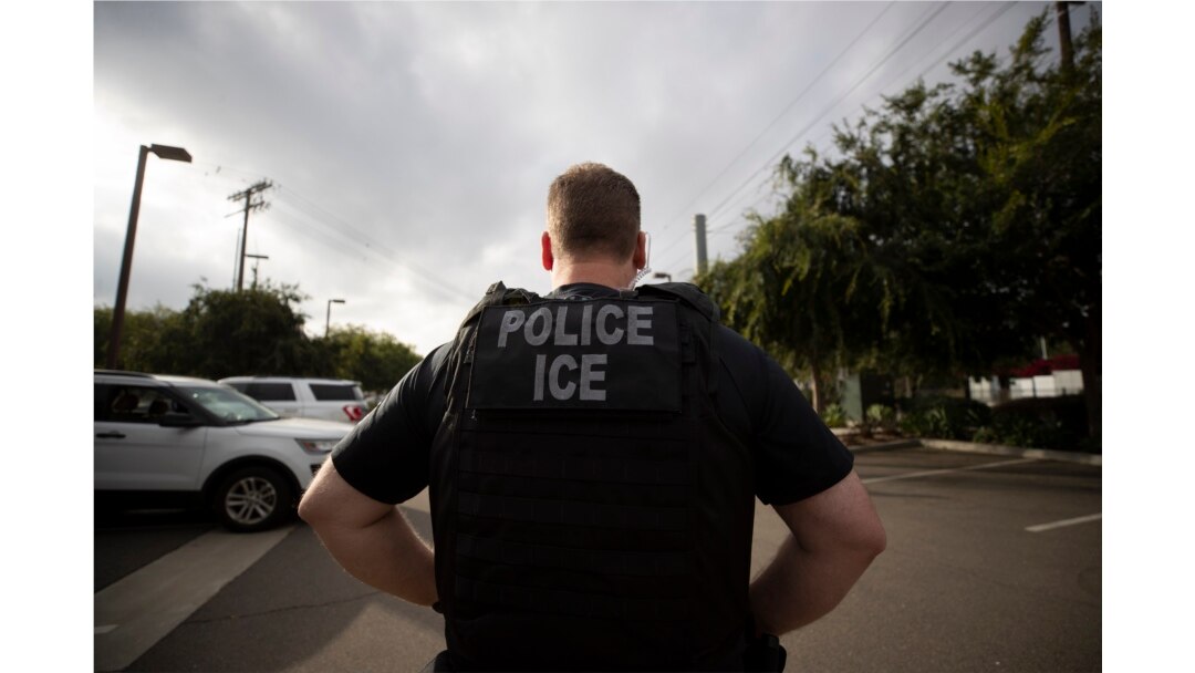 FILE - A U.S. Immigration and Customs Enforcement officer looks on during an operation in Escondido, Calif., July 8, 2019.