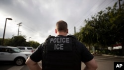 FILE - In this July 8, 2019, file photo, a U.S. Immigration and Customs Enforcement (ICE) officer looks on during an operation in Escondido, Calif. 