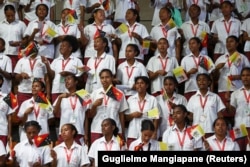 Siswa Sekolah Menengah Teknik Caritas melambaikan bendera Vatikan dan Papua Nugini saat Paus Fransiskus tiba di Port Moresby, Papua Nugini, 7 September 2024. (Foto: REUTERS/Guglielmo Mangiapane)