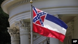 FILE - The Mississippi state flag is unfurled against the front of the Governor's Mansion in Jackson, Mississippi, June 23, 2015.