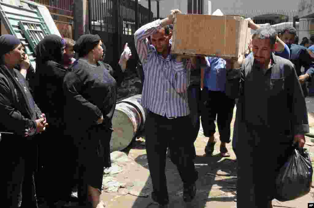 Egyptians remove a body for burial from the Zenhoum morgue in Cairo, August 19, 2013.