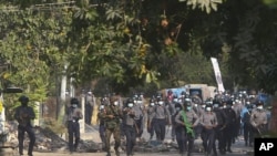 Myanmar riot police crossing a blockage during a protest against the military takeover in Mandalay, Myanmar, Sunday, Feb. 28, 2021. (AP Photo)