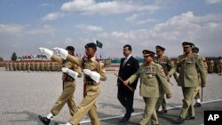 Pakistan's Prime Minister Yusuf Raza Gilani (C, rear) reviews an honor guard during a passing out ceremony in Quetta October 11, 2011