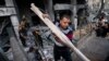 People salvage items from inside the severely damaged Al-Jawhara building following a cease-fire reached after an 11-day war between Gaza's Hamas rulers and Israel, in Gaza City, May 21, 2021.