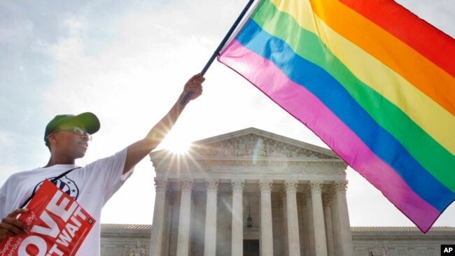 Carlos McKnight of Washington, waves a flag in support of gay marriage outside of the Supreme Court in Washington, D.C., June 26, 2015. (AP)