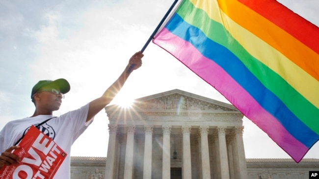 Carlos McKnight of Washington, waves a flag in support of gay marriage outside of the Supreme Court in Washington, D.C., June 26, 2015. (AP)