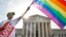 Carlos McKnight waves a flag in support of gay marriage outside of the Supreme Court in Washington, D.C. The Court on Friday declared same-sex couples have a right to marry anywhere in the country, essentially invalidating laws in some states barring same-sex marriage.