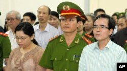 FILE - A U.S-trained lawyer and well-known dissident Le Quoc Quan, right, listens to the judge during his trial in Hanoi, Vietnam.