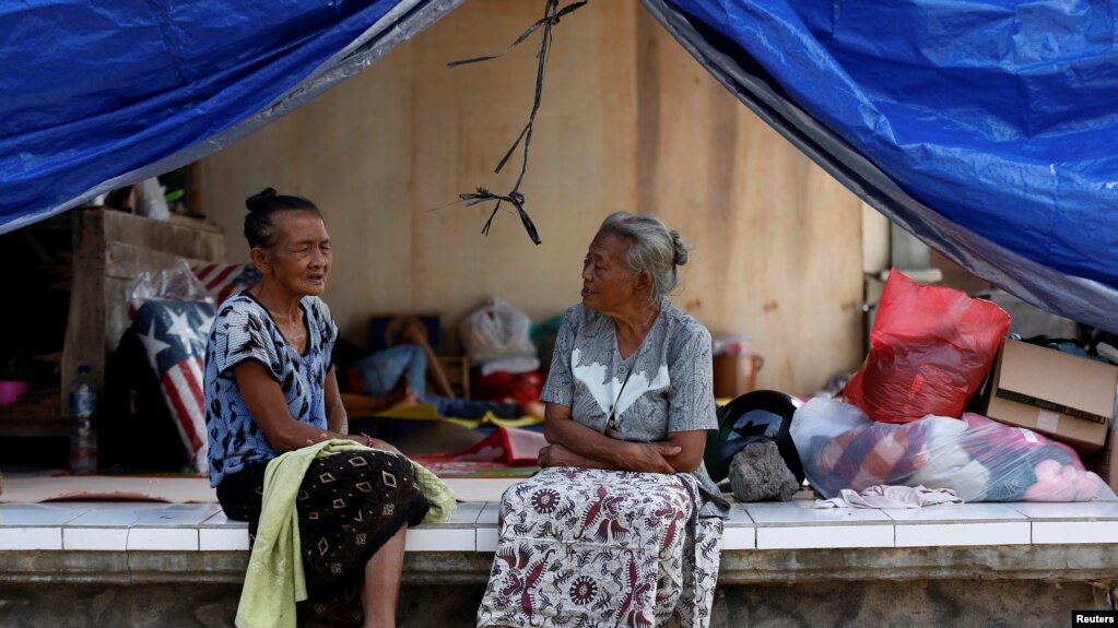 Dua perempuan lansia tengah berbincang di tenda evakuasi sementara di dekat Gunung Agung, kawasan Manggis, Bali, 1 Oktober 2017. (REUTERS/Darren Whiteside)