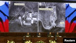 Pejabat-pejabat Kementerian Pertahanan Rusia memberikan penjelasan dengan menggunakan layar monitor, di Moskow hari Rabu (2/12). 