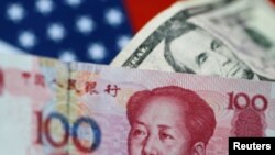 FILE - U.S. dollar and China yuan notes are seen in this picture illustration, June 2, 2017. 