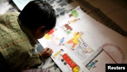 FILE - An Indian boy sketches a painting in a classroom at a boys' welfare home in New Delhi.