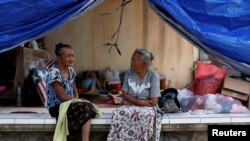 Dua perempuan lansia tengah berbincang di tenda evakuasi sementara di dekat Gunung Agung, kawasan Manggis, Bali, 1 Oktober 2017. (REUTERS/Darren Whiteside)