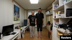 Kim Young-lae, right, and Kim Sung-sil, parents of Kim Dong-hyuk, a high school student who died in the Sewol ferry disaster, pose for a photograph in their son's room, Ansan, South Korea, April 8, 2015. 