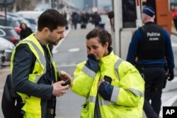 People react outside Brussels airport after explosions rocked the facility in Brussels, Belgium Tuesday March 22, 2016.