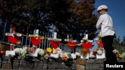 FILE - A woman looks at memorials along a bike path to remember the victims of the October 31 attack, in New York City, Nov. 3, 2017.