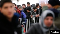 Migrants queue inside a tent at the compound outside the Berlin Office of Health and Social Affairs waiting to register in Berlin, Germany, Dec. 1, 2015. 